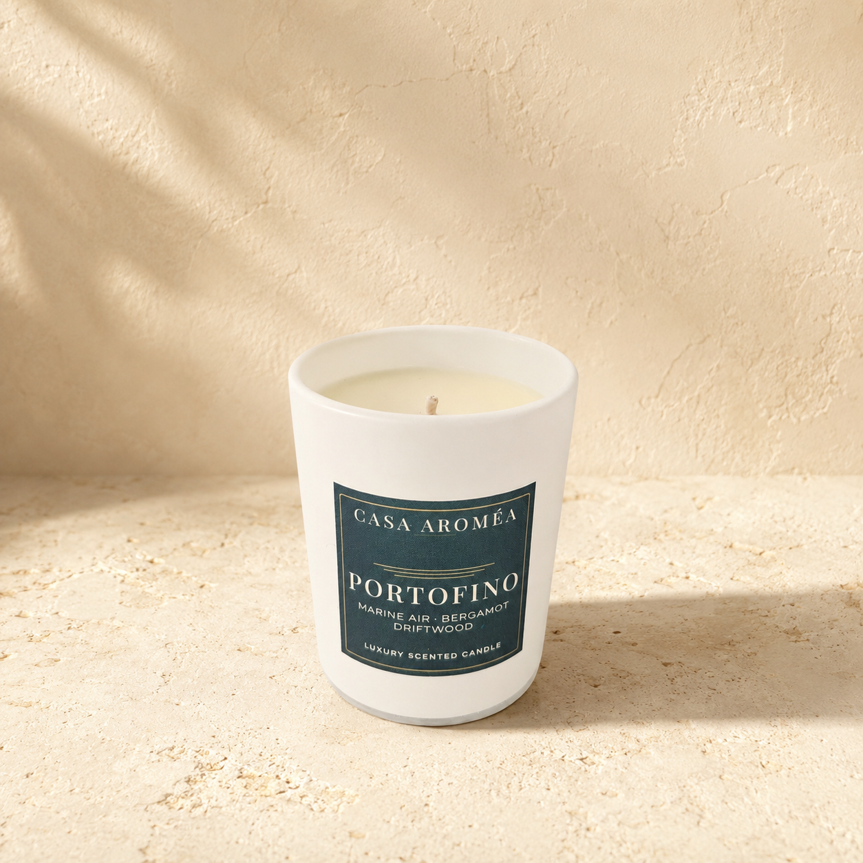 Small Portofino scented candle by Casa Aroméa in a white glass vessel against a warm Mediterranean-inspired textured background