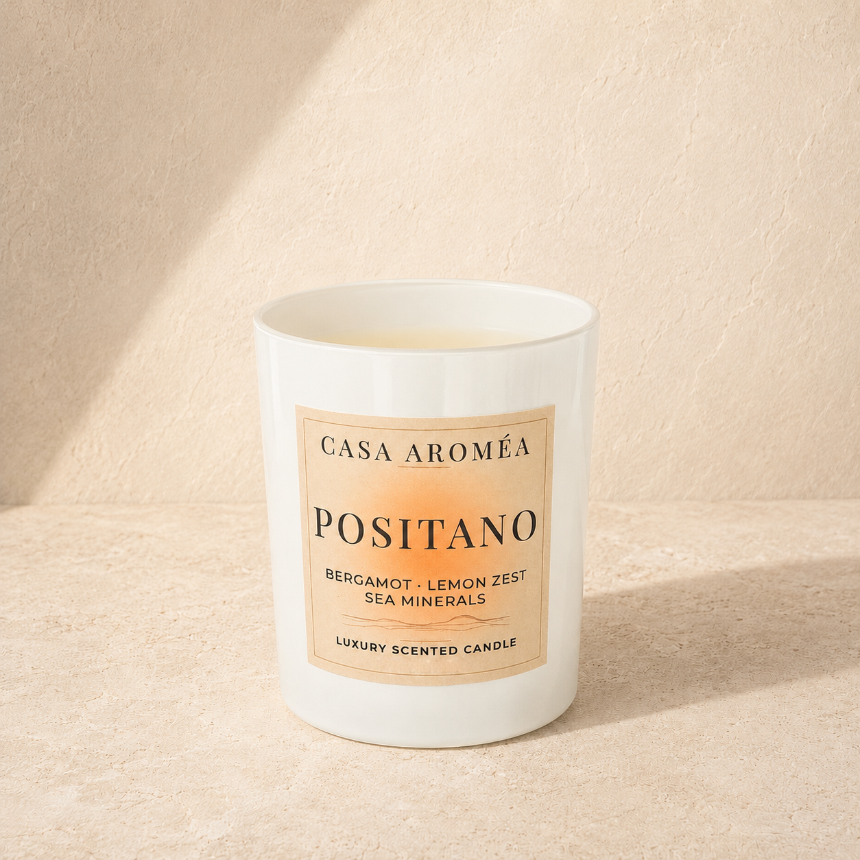 Large Positano scented candle by Casa Aroméa in a white glass vessel against a warm Mediterranean-inspired textured background