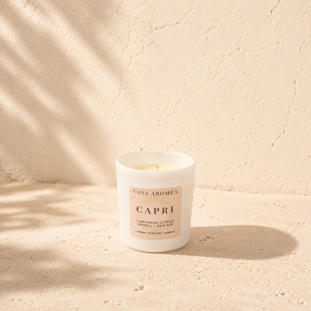 Small Capri scented candle by Casa Aroméa in a white glass vessel against a warm Mediterranean-inspired textured background